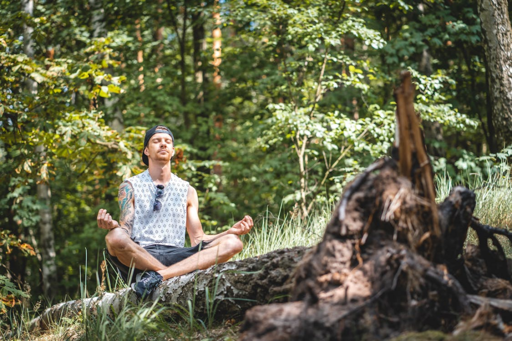 A young man meditating in the woods