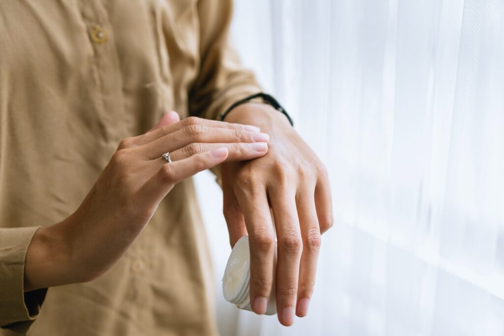 Woman rubbing ointment on a sore hand