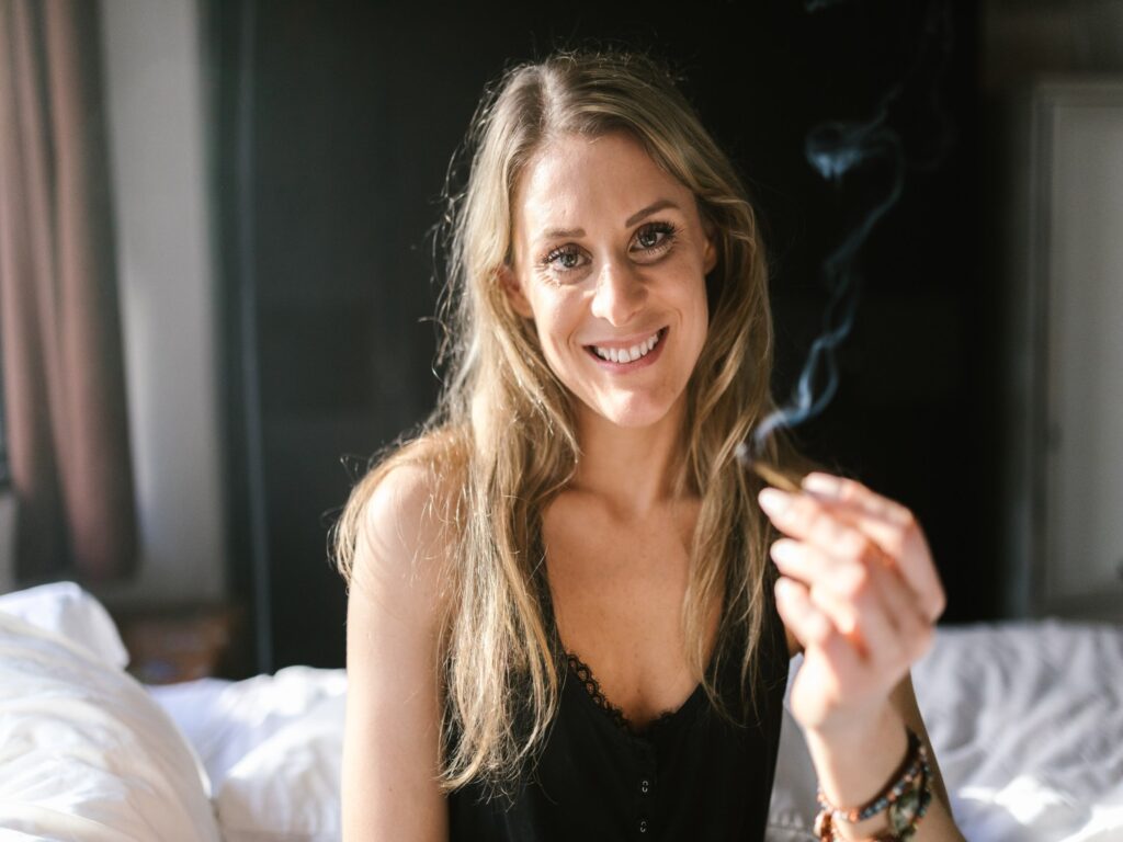 A woman smiling and smoking a joint