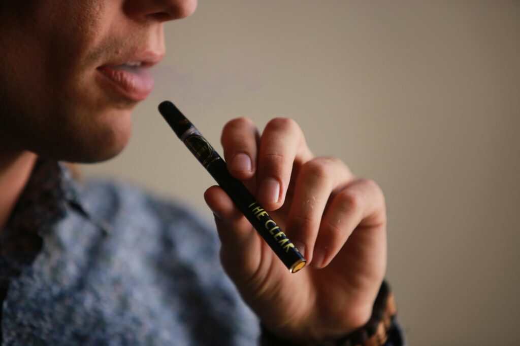 A person smoking with a vape pen